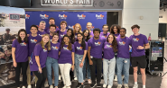 A large group photo of interns wearing purple FedEx Cares t-shirts 