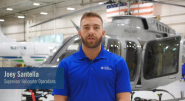 A Duke Energy employee interviewed in front of a helicopter in a hanger. 