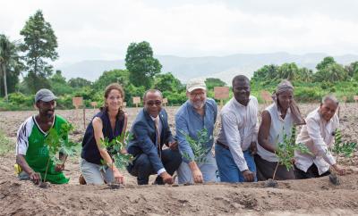 The Smallholder Farmers Alliance (SFA) and partners plant cotton seeds to reintroduce cotton to Haiti after a 30-year hiatus. Tree seedlings, transplanted elsewhere after the ceremonial planting, symbolize the unique connection between trees and cotton in the SFA/Timberland agroforestry model. Pictured (left to right): Thony Thomas, smallholder farmer; Atlanta McIlwraith, Timberland; Pierre Marie Du Mény, Haitian Minister of Commerce and Industry; Hugh Locke, SFA; Timote Georges, SFA; Nerlande Dautarn, smallholder farmer; Rémillot Léveillé, agronomist who is known as the “father of cotton” in Haiti. Photo credit: SFA/Thomas Noreille.