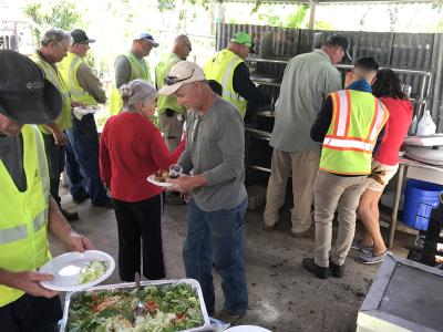Linemen fix their plates at the home of a customer whose power they recently restored. The family made them this lunch as a thank you.