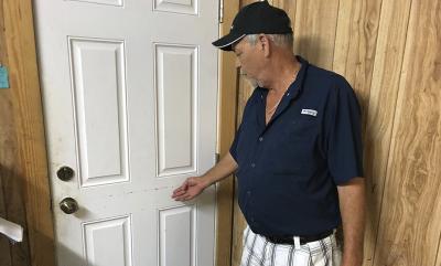 Joseph "Smokey" Parrish shows the tidemarks left by flooding at Buddy Ward and Sons Seafood's warehouse in Apalachicola.