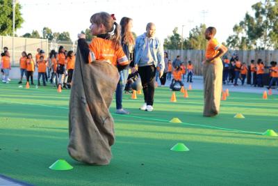 Children from the Boys & Girls Club of Carson participate in fitness drills, such as potato sack hopping at Rally Health’s Holiday Bike Build at StubHub Center on December 5, 2017.