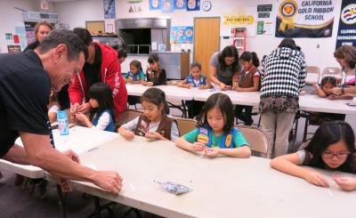 Using LED lightbulbs, aluminum tape and batteries, the first and second graders put together their own electrical circuits.
