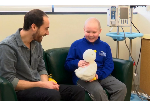 In this undated photo made from video, 12-year-old cancer patient Ethan Daniels at medical facility in Atlanta speaks with Aaron Horowitz, co-founder and CEO of Sproutel, who designed “My Special Aflac Duck” to promote emotional well-being by helping children living with cancer develop a sense of control and manage stress through interactive technology. (Image courtesy of Marina Hutchinson/Associated Press)
