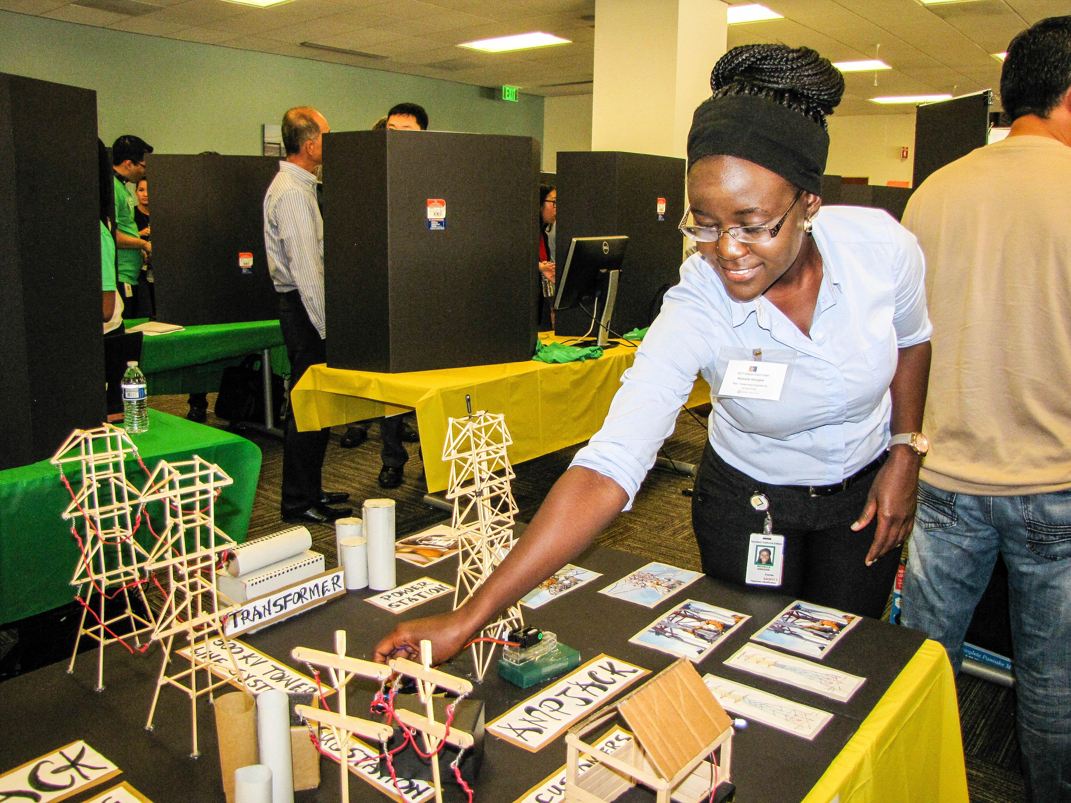 Michelle Wangwa, a Transmission and Distribution intern, demonstrates the technology behind SCE’s AMPJack tower raising technique with her miniature model.