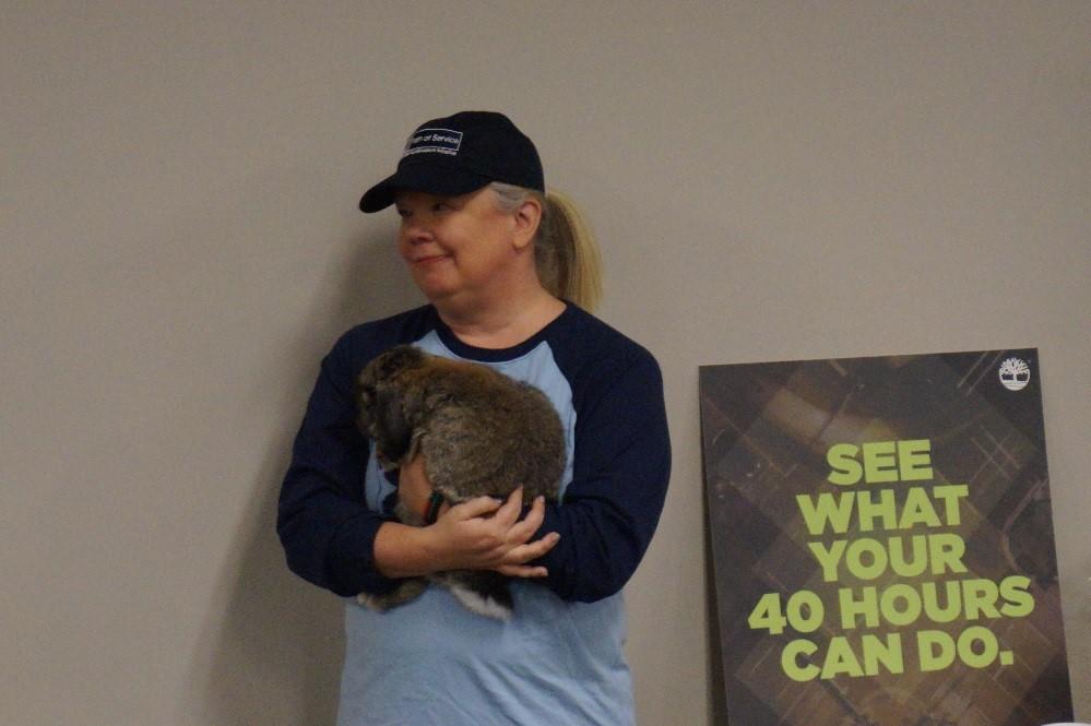 Jill Holt, Timberland’s community engagement coordinator, holds a Girls at Work therapy rabbit while listening to speakers at Timberland’s 2017 40’s Club Breakfast. This year’s breakfast recognized a record breaking 163 employees who served all 40 of their available service hours.